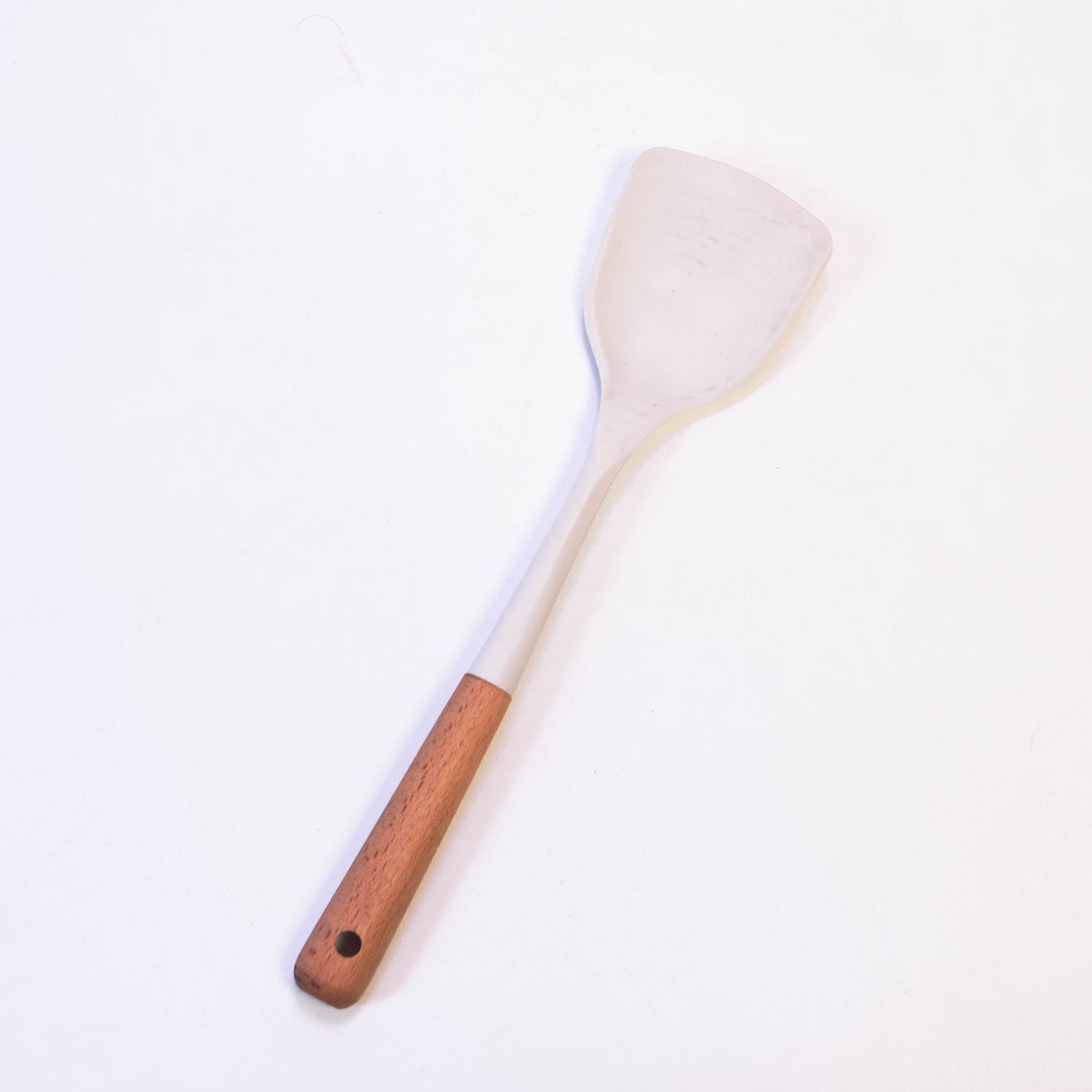 White wooden handle silicone solid turner from Zoni Stores, heat-resistant and non-stick, suitable for flipping and serving food.