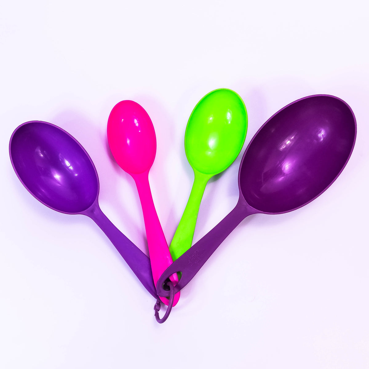 Set of clear plastic measuring cups from ZoniStores with measurement markings, stacked together on a white surface.