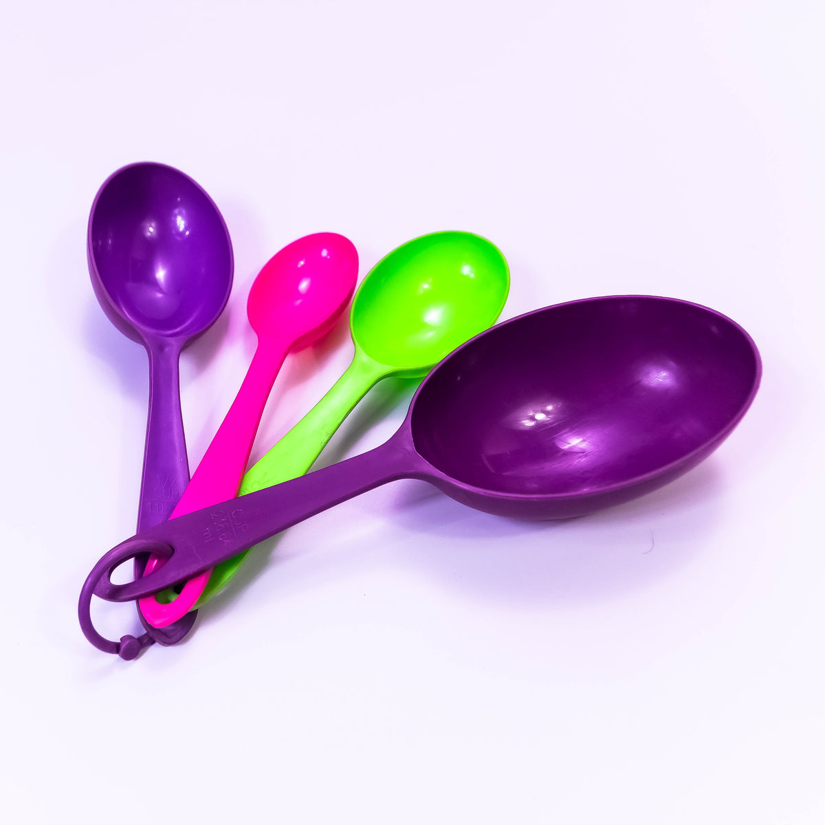 Set of clear plastic measuring cups from ZoniStores, stacked with measurement markings visible for cooking and baking.