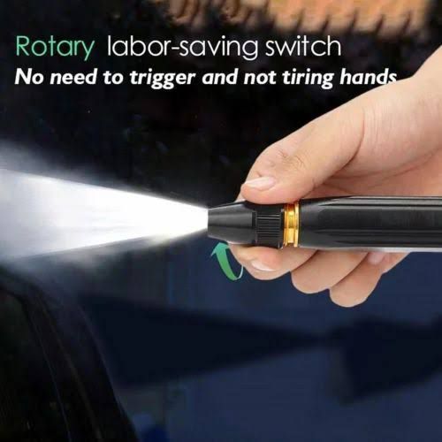 Close-up of a hand operating a black and gold metal water spray nozzle with a rotary switch mechanism spraying a continuous stream of water.