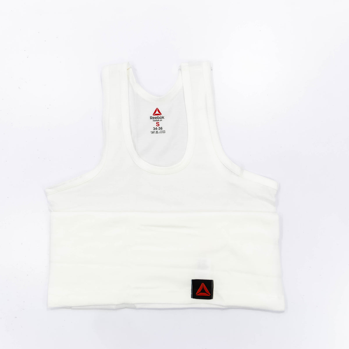 Zoni Stores branded Reebok vest displayed on a hanger, featuring a sleeveless athletic design with the Reebok logo visible.
