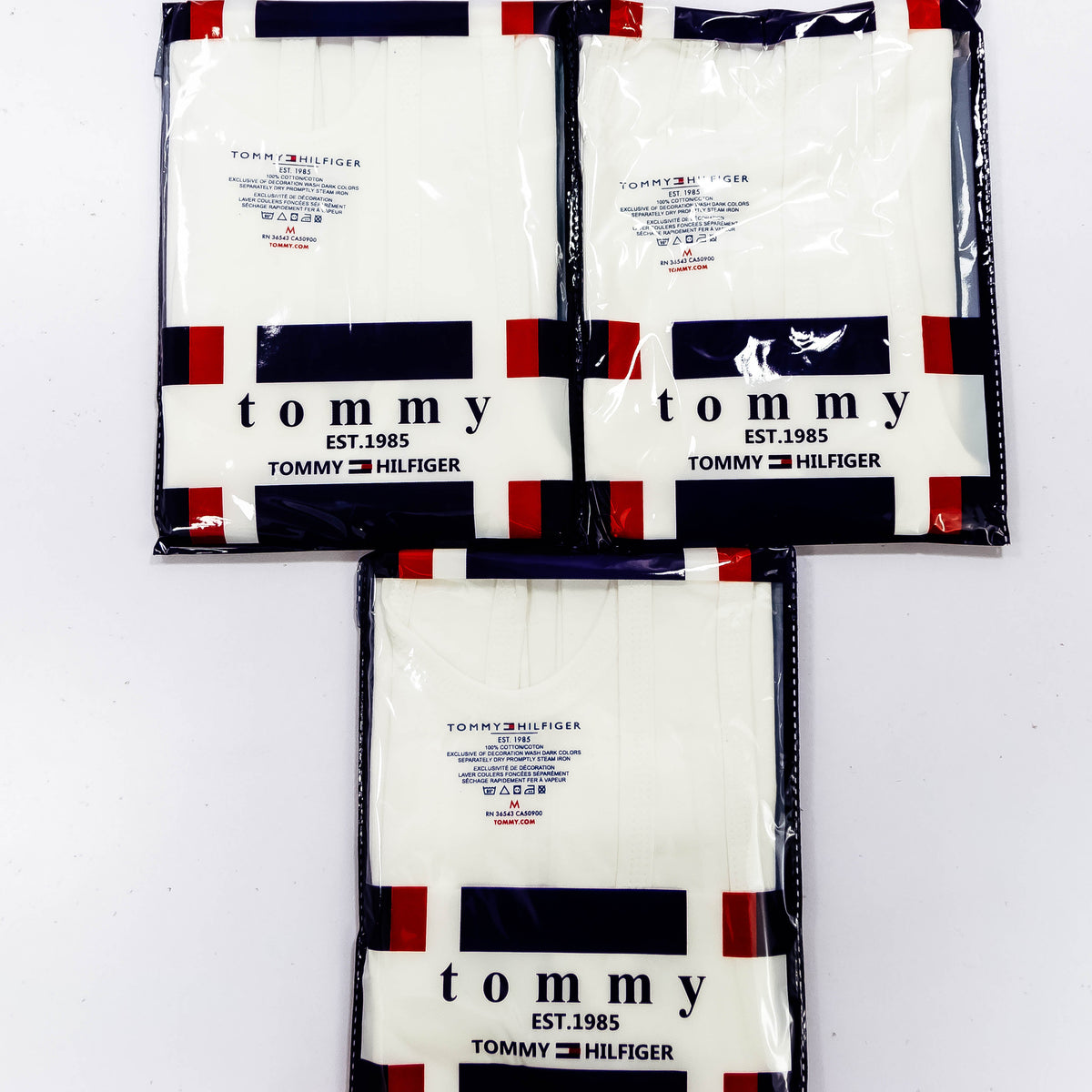 Pack of three Zoni Stores Tommy Hilfiger branded vests in assorted colors, featuring crew neck and sleeveless design.