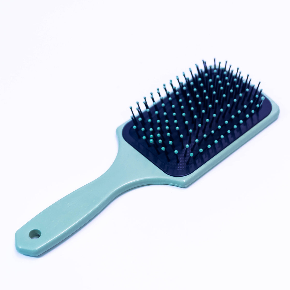 Sea green printed hair brush by Zoni Stores, showing textured handle and bristles suitable for detangling and styling hair.