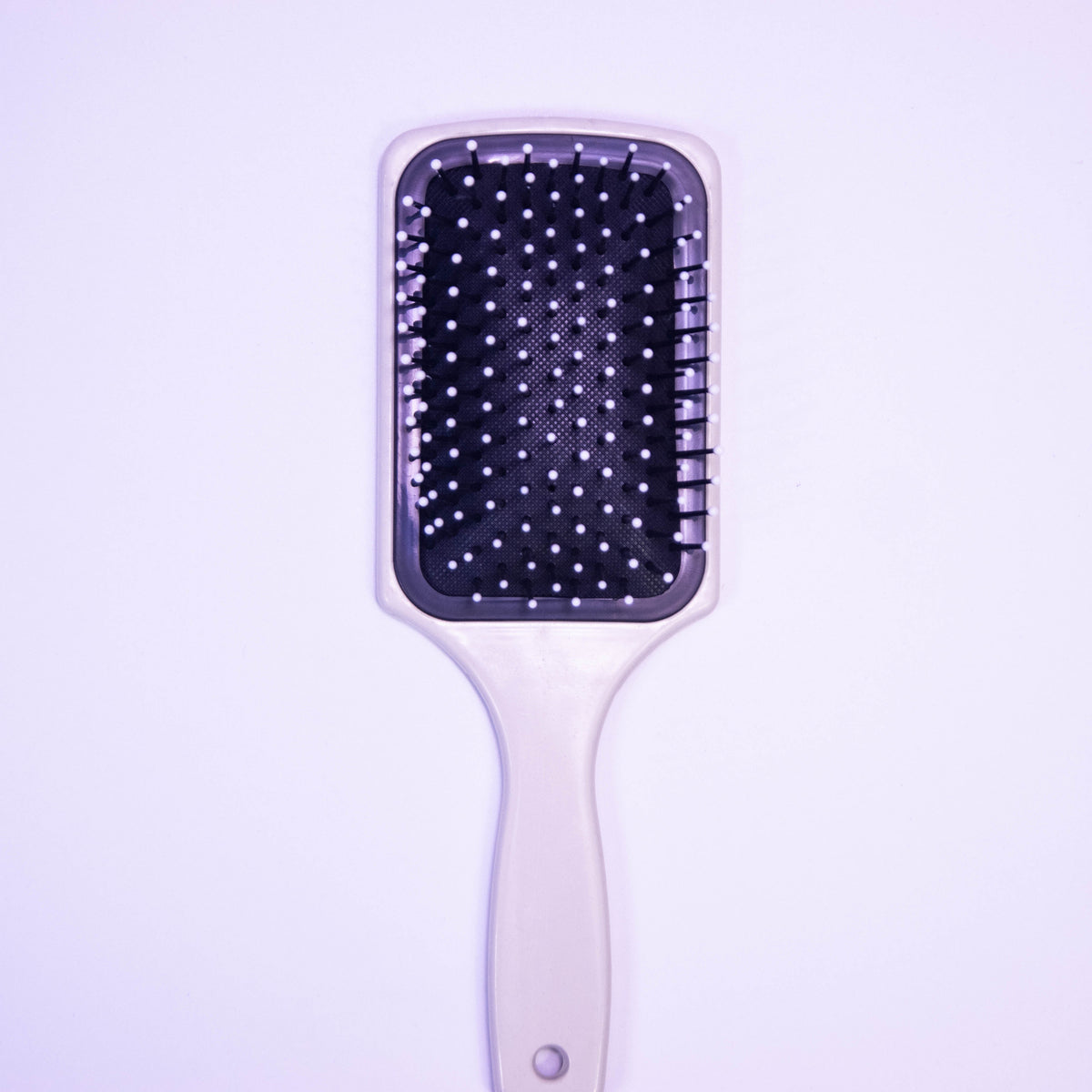 Printed pale violet hair brush by Zoni Stores with ergonomic handle and soft bristles, shown on a clean surface.