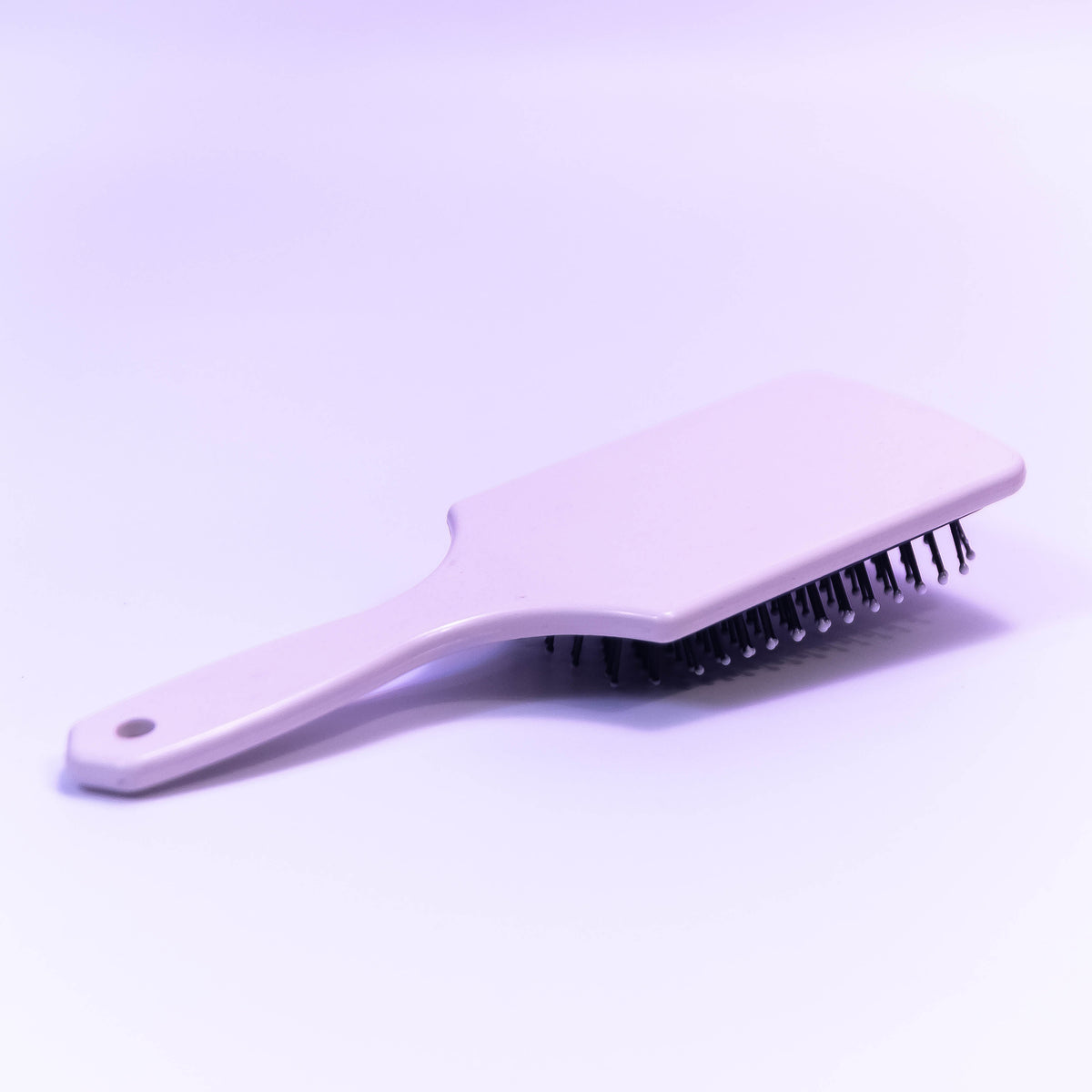 Printed pale violet hair brush by Zoni Stores with a decorative design, featuring soft bristles for gentle styling.
