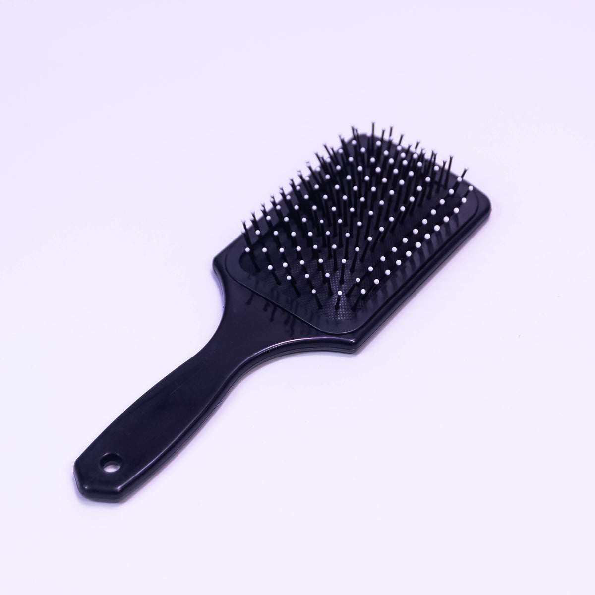 Printed black hair brush by Zoni Stores, showing a close-up of the textured bristle side for gentle hair detangling.
