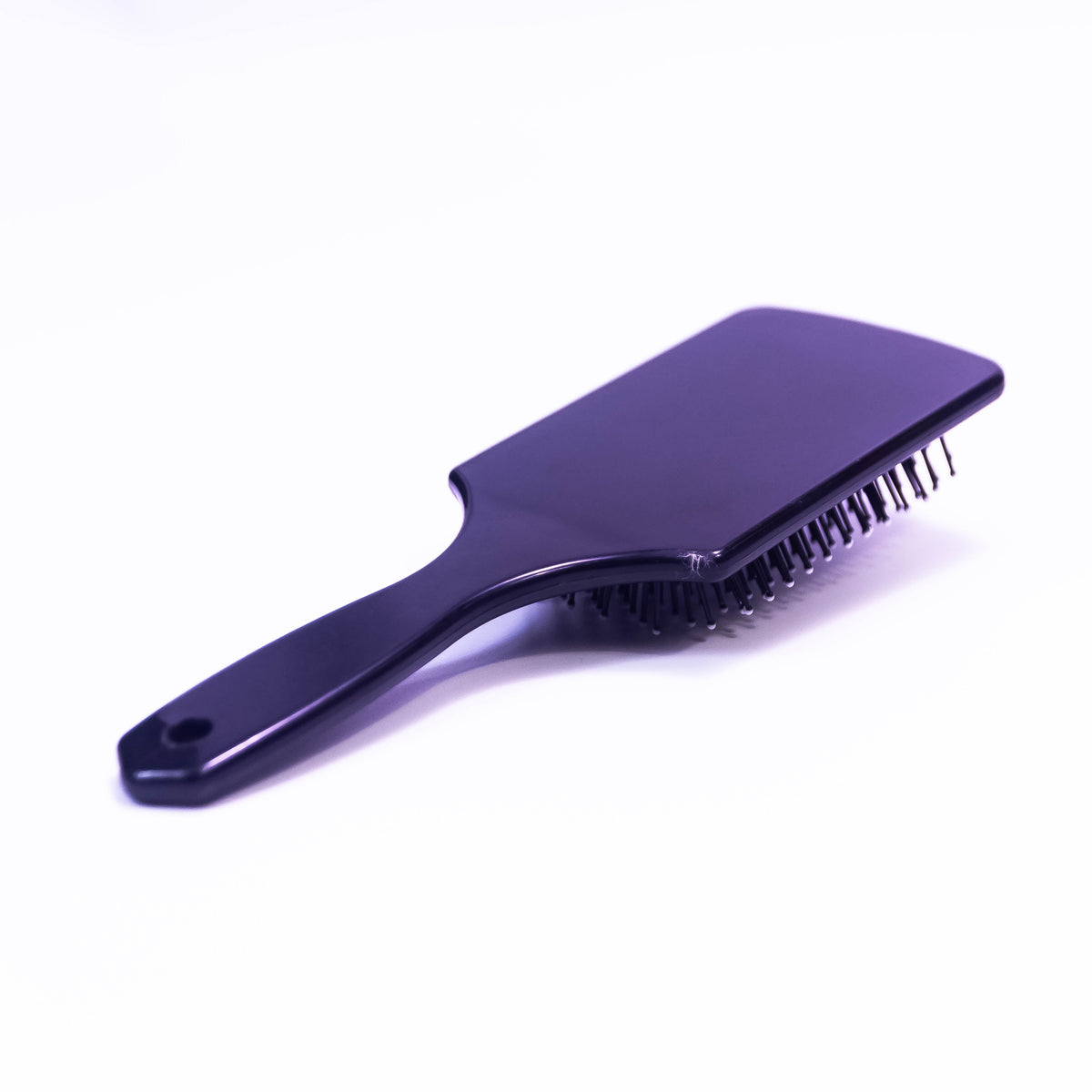 Printed black hair brush by Zoni Stores with a textured handle and bristles for detangling and styling hair.