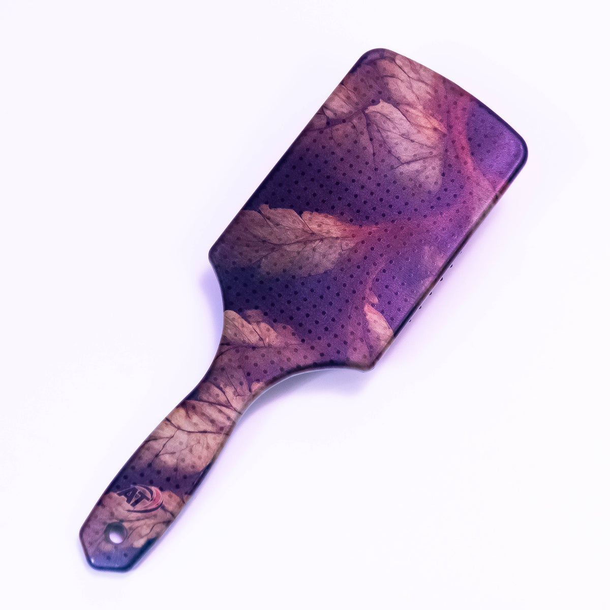 Printed autumn leaf hair brush by Zoni Stores with colorful leaf design, featuring ergonomic handle and flexible bristles.