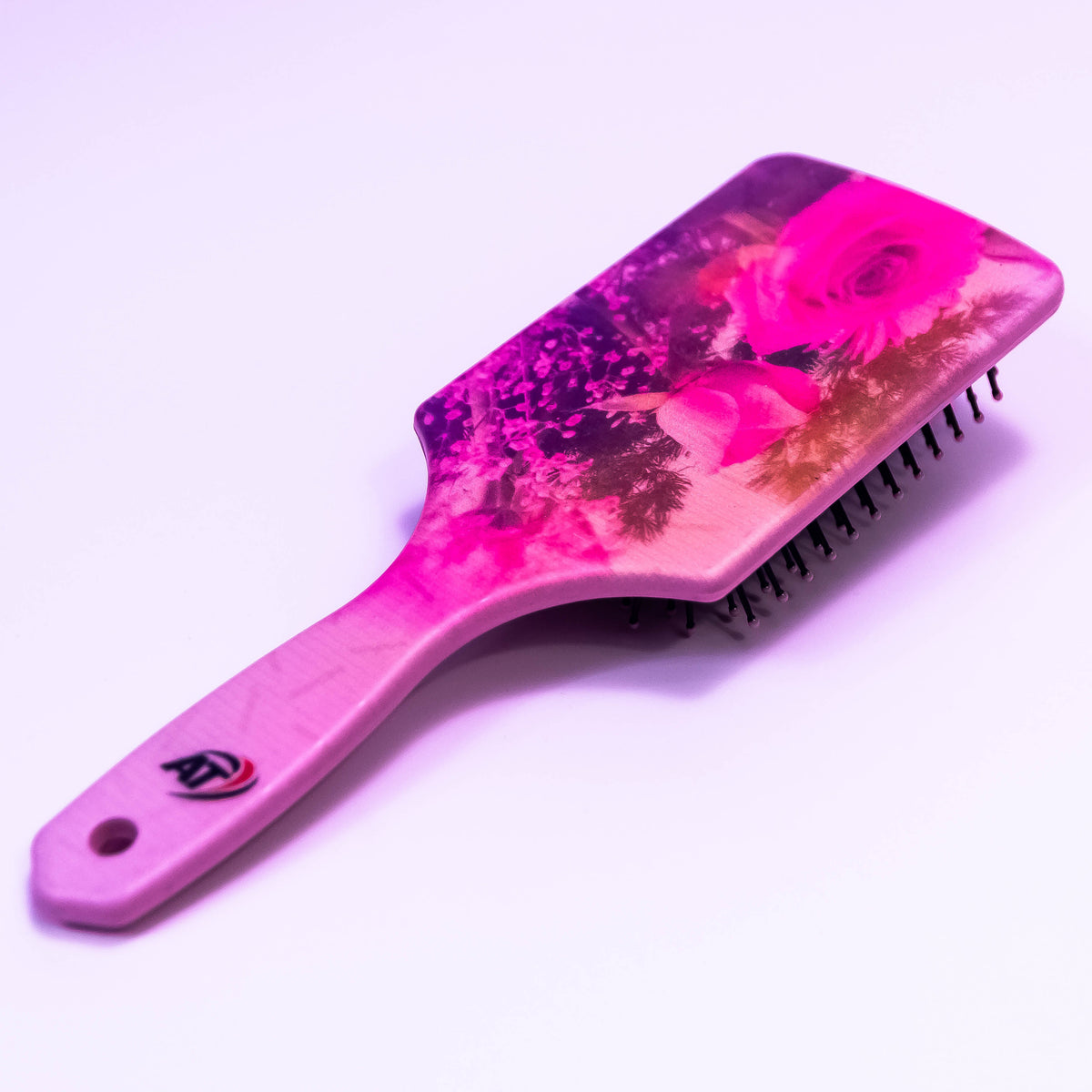Pink star floral printed hair brush by Zoni Stores with a sleek handle and floral design for gentle detangling and styling.