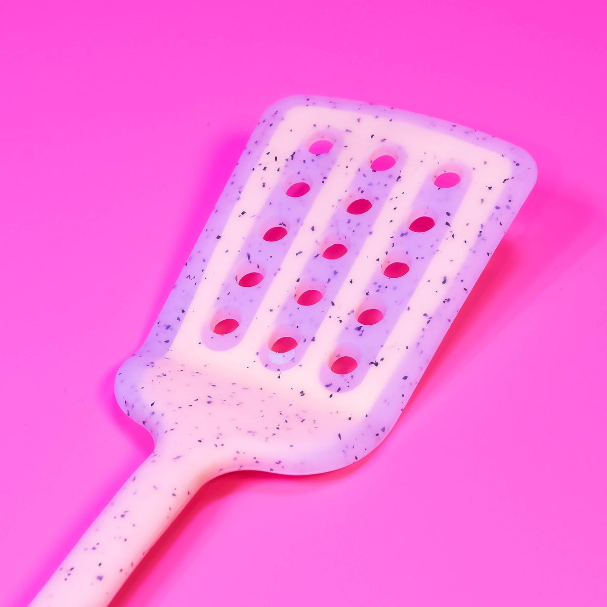 Colorful silicone slotted turner from Zoni Stores with long handle, ideal for flipping and serving in the kitchen.