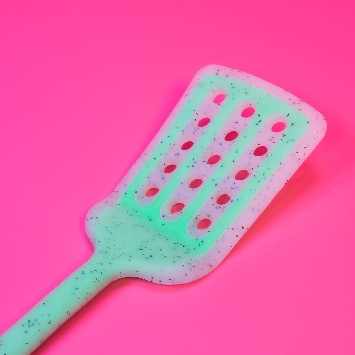 Colorful silicone slotted turner from Zoni Stores, long kitchen utensil with slotted head for flipping and serving food.