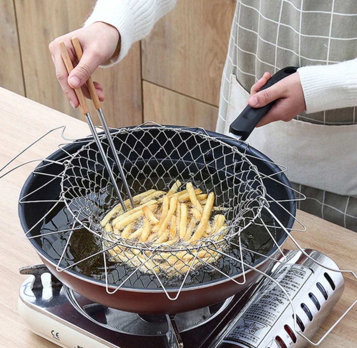 Foldable wire mesh kitchen fry basket hanging on a hook in Pakistan by Zoni Stores