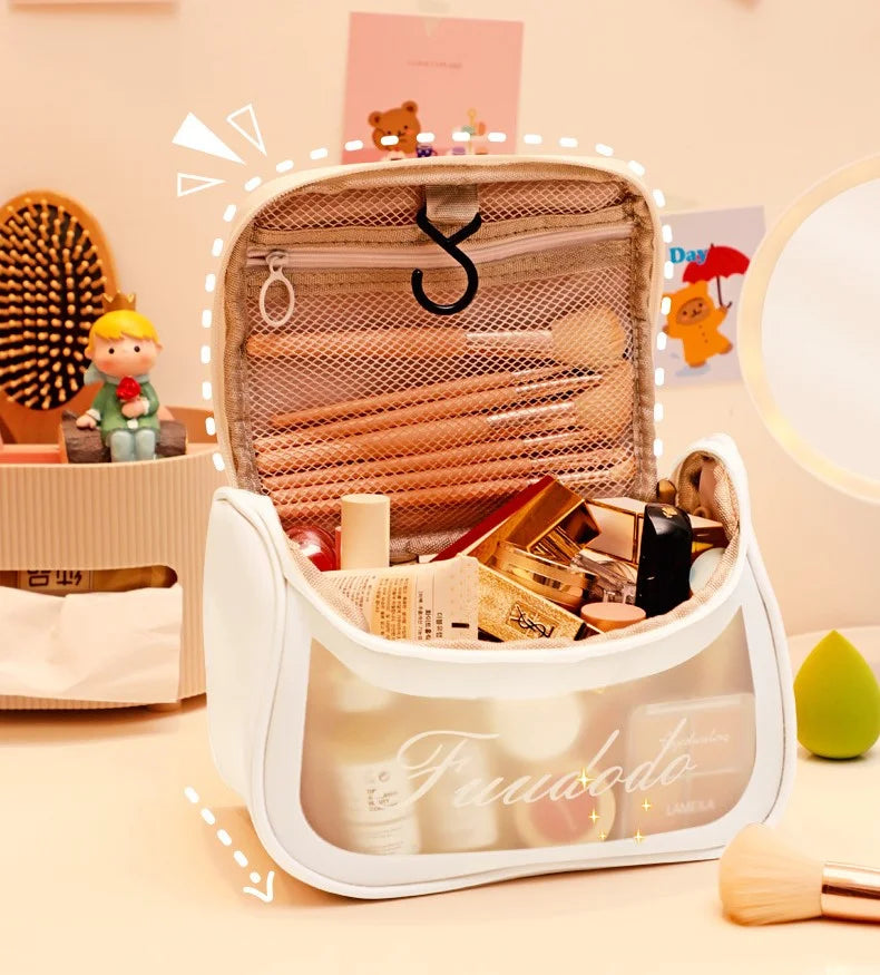 Aesthetic white makeup pouch with Fundodo cursive text print, displayed in a warm lit room next to decor.